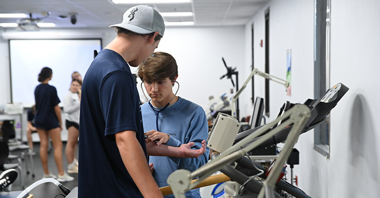 student taking the blood pressure of an athlete