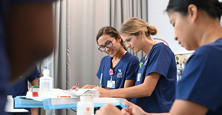 Three nurses writing in a hospital setting