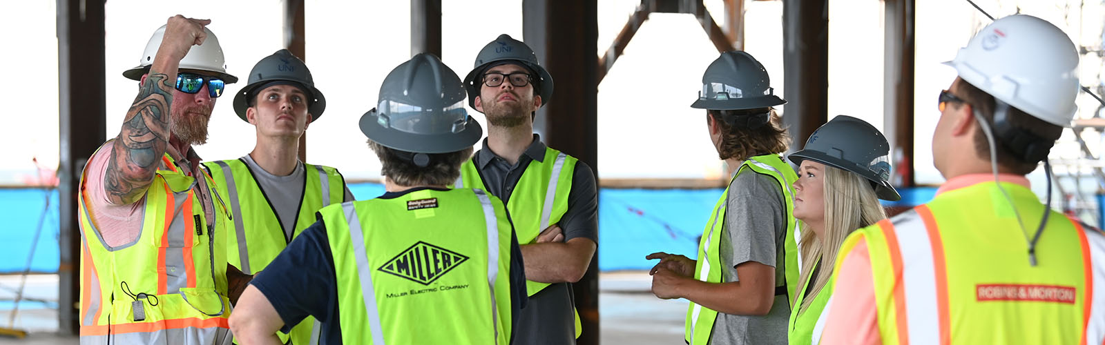 students with a supervisor in a building under construction