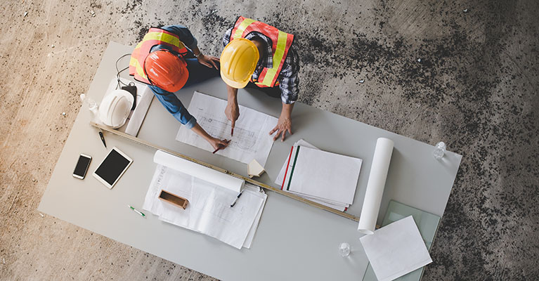 civil engineers going over a blueprint on a table