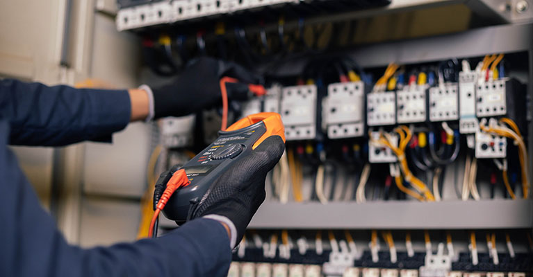 engineer tests installations and wires on relay protection system
