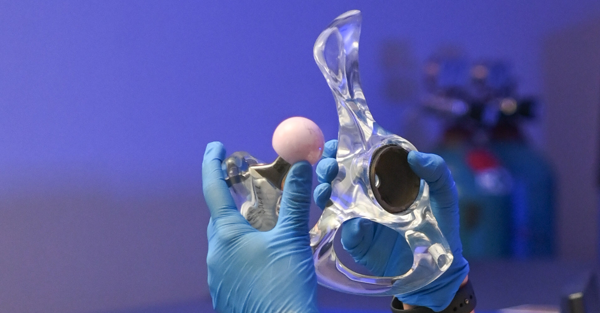 gloved hands holding a 3d print of a joint
