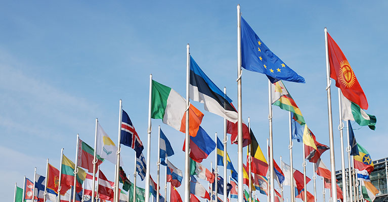 various international flags waving on flag poles
