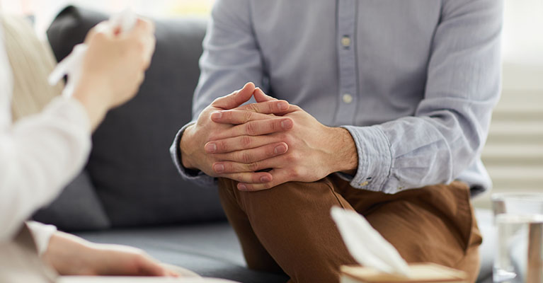 person clasping hands around his knee