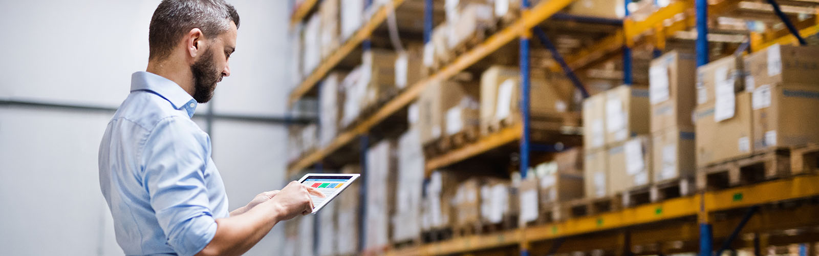 man with a tablet looking at inventory in a warehouse