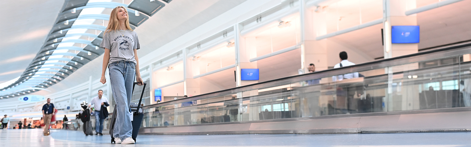 student walking in the airport smiling