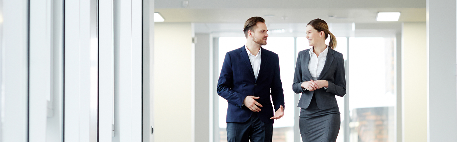 two administrators walking down a well-lit hallway