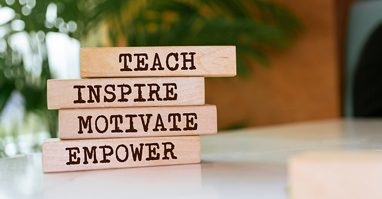 blocks on a desk with teach inspire motivate empower