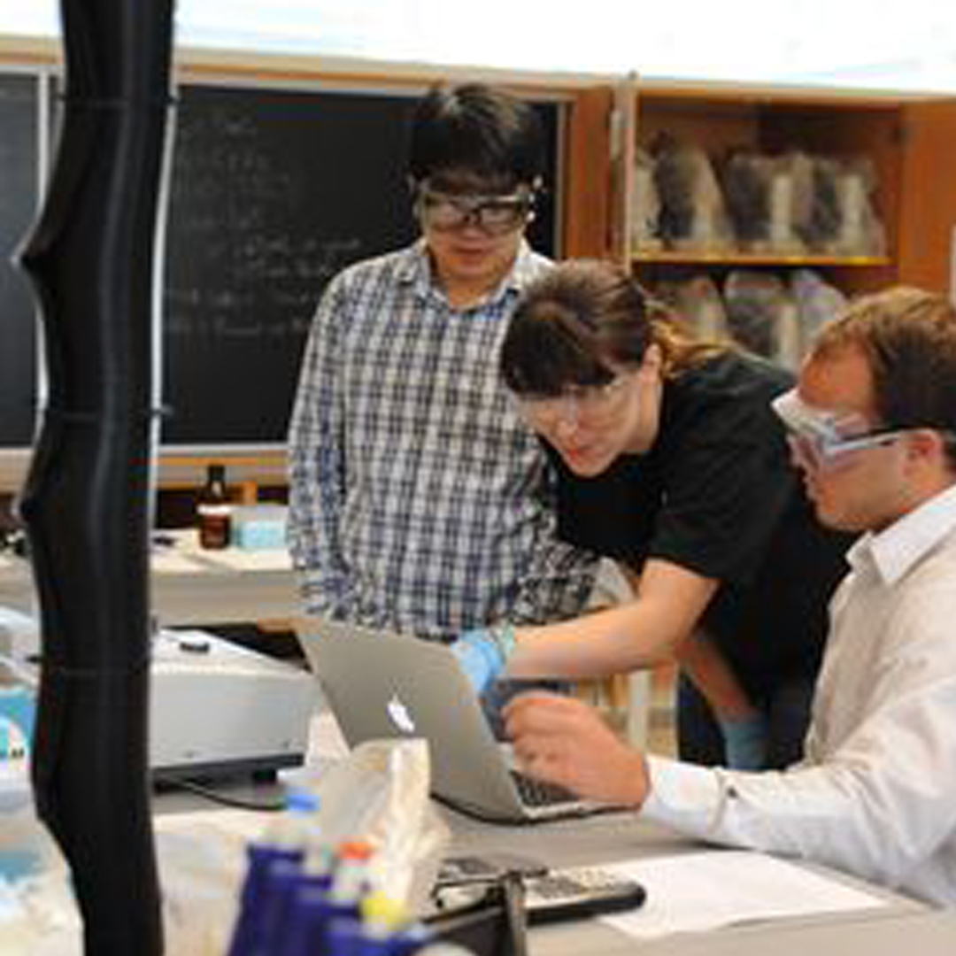 Professor working with students in a lab