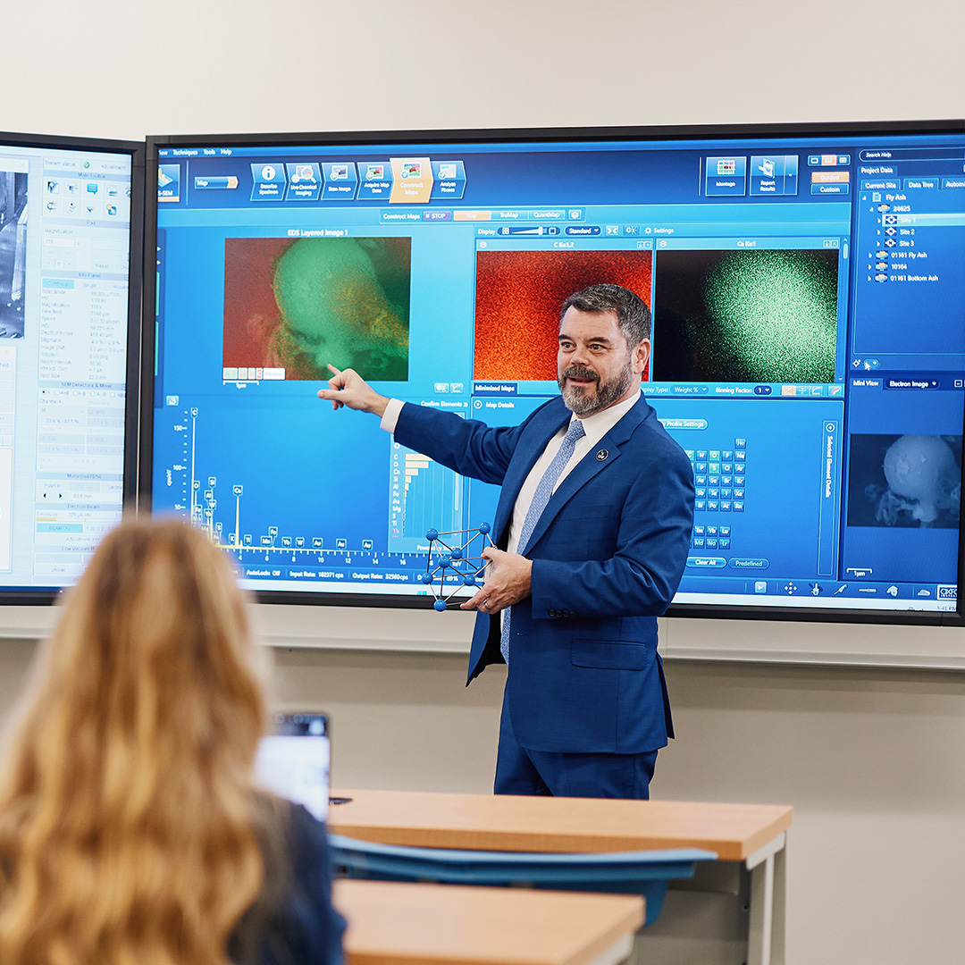 Professor teaching using interactive white board to display maps