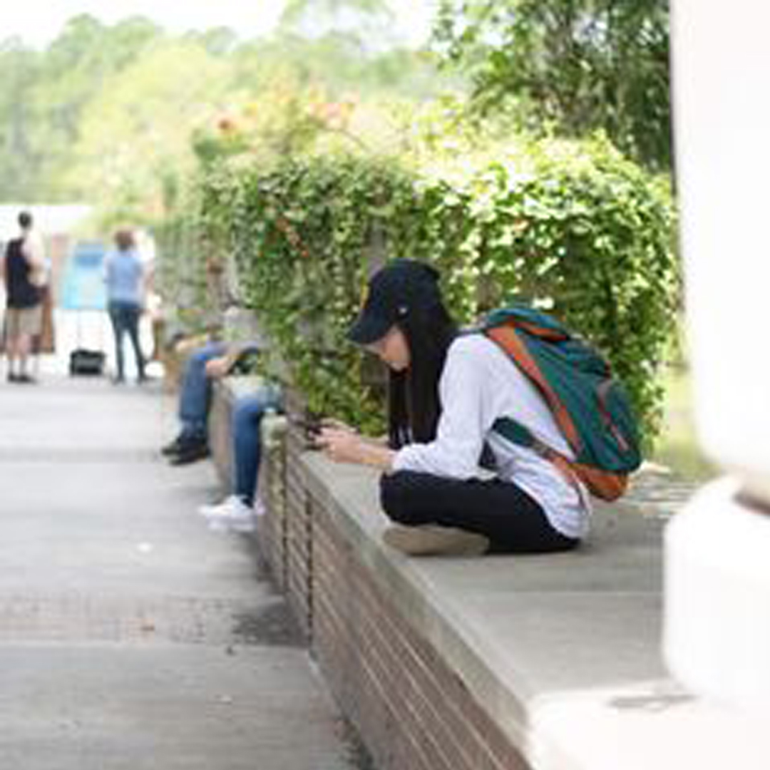student sitting on wall