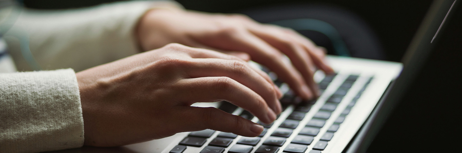 Zoomed in photo of hands typing on a keyboard