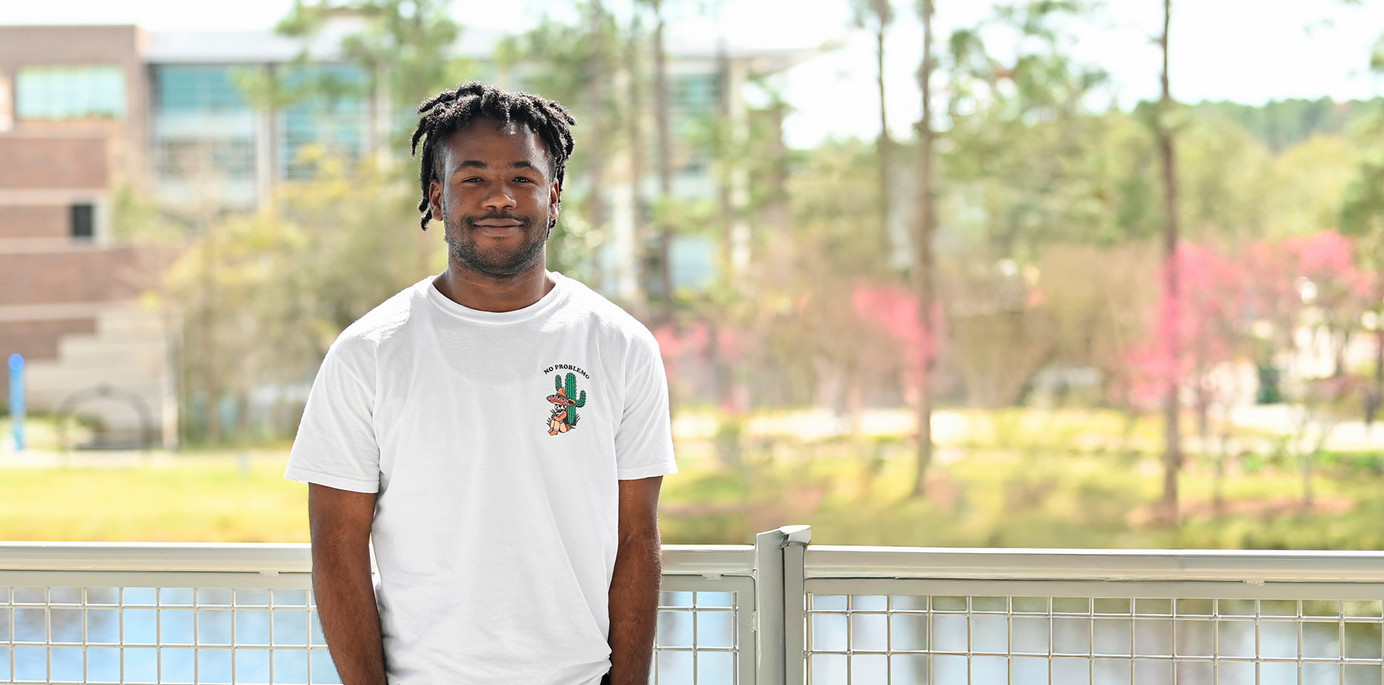 smiling student standing on the second floor of the student union
