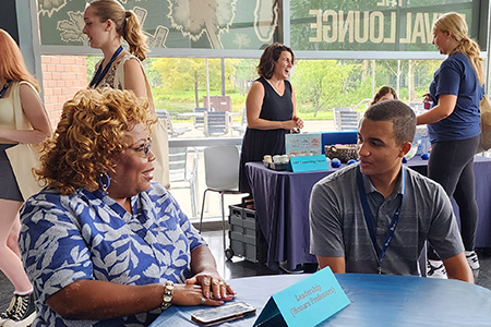 professor talking to a student at a networking event