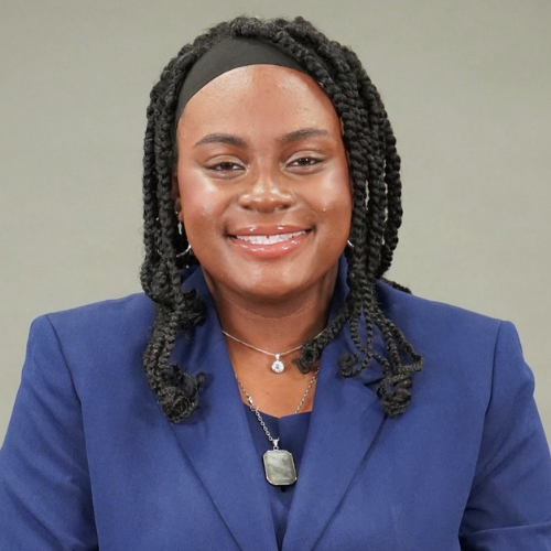 Tanasha Jackson in blue suit and gray background