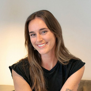 headshot of smiling woman wearing black top. 