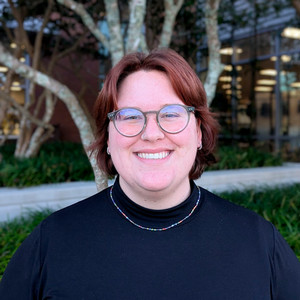 Headshot of nonbinary person smiling 