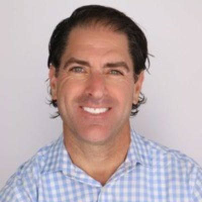 Jamie Marchio - Man smiling at a camera with a buttoned shirt