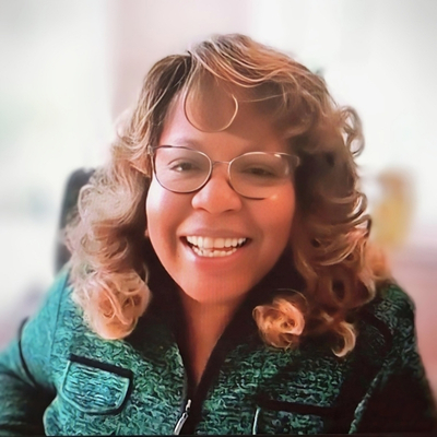 Dr. Wamble-King smiling in a green shirt, white background