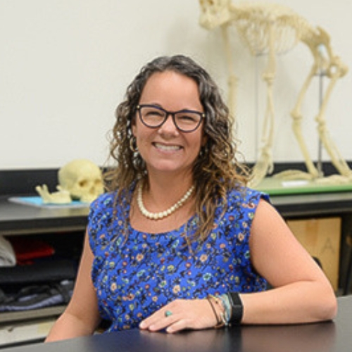 Anne Pfister with fossils behind her. 