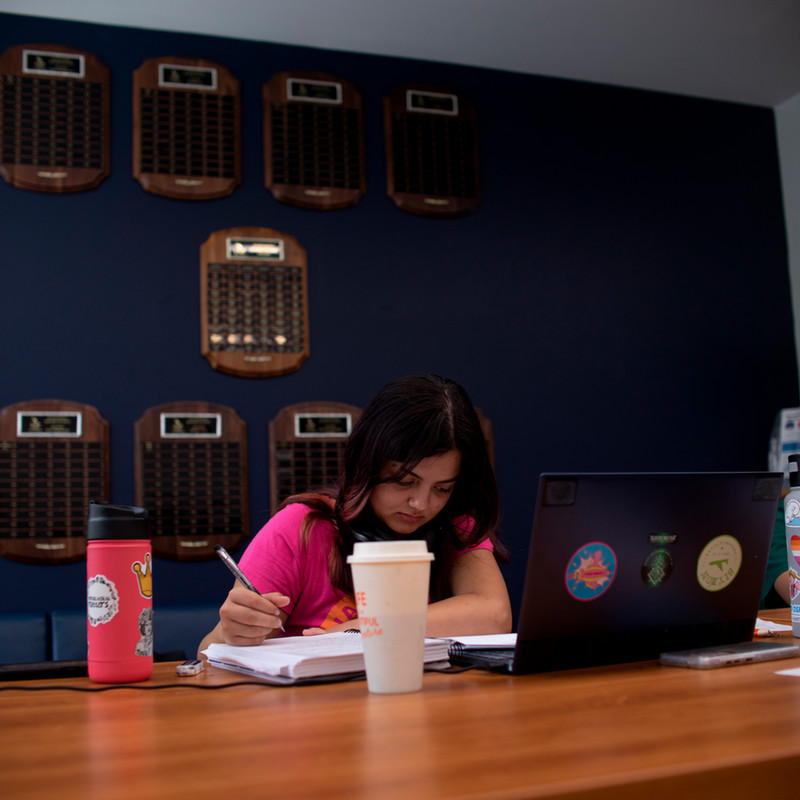 Student studying at a table in the community room.