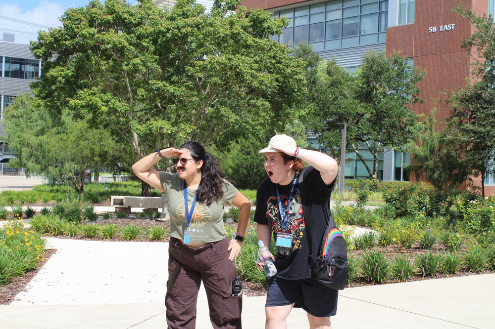 Students posing while wearing a mustache and hat