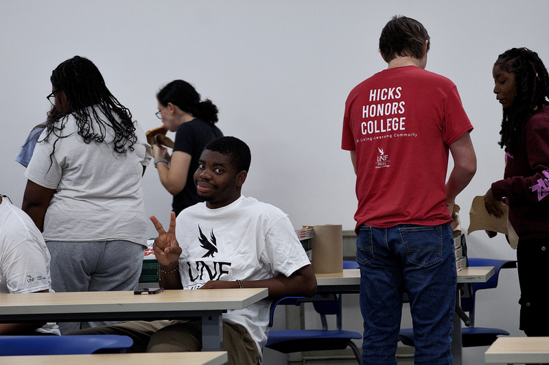Hicks Honors College student making a peace sign with his fingers.