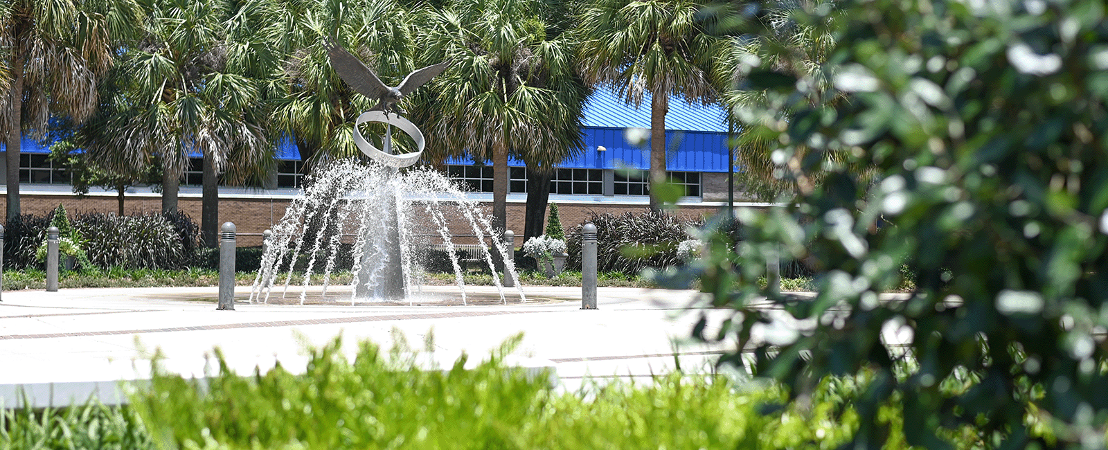 osprey fountain in the background with green grass and bushes in front