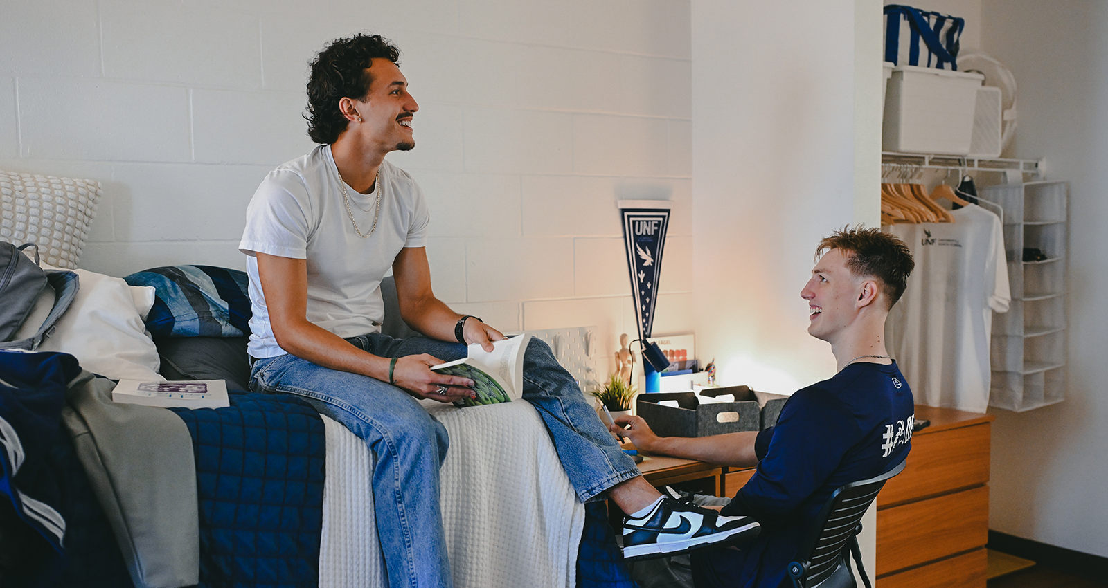Two UNF residents studying, laughing and having fun in their room on campus