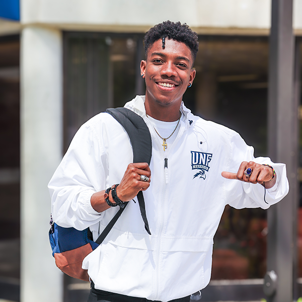 UNF resident in UNF housing area smiling on a beautiful sunny day