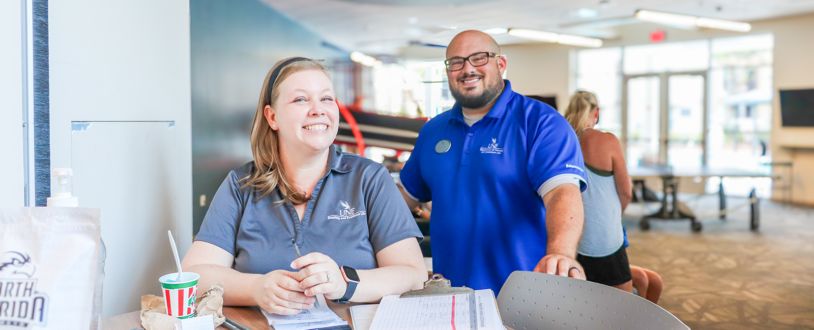Two housing staff member smiling at Osprey Clubhouse working at an event