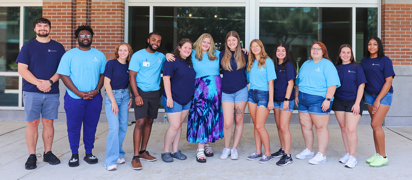 group of smiling students in front of the Fine Art Center