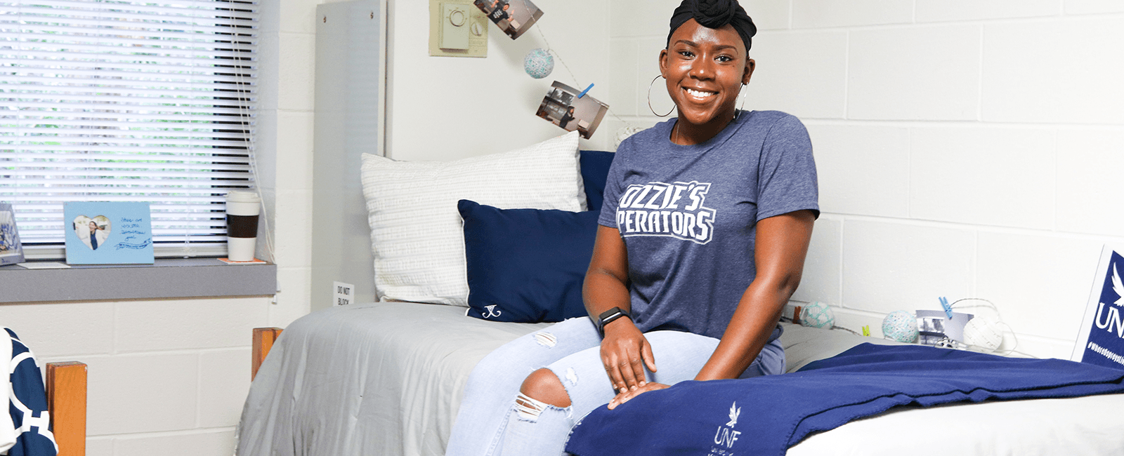 resident sitting and smiling in osprey cove unf themed room