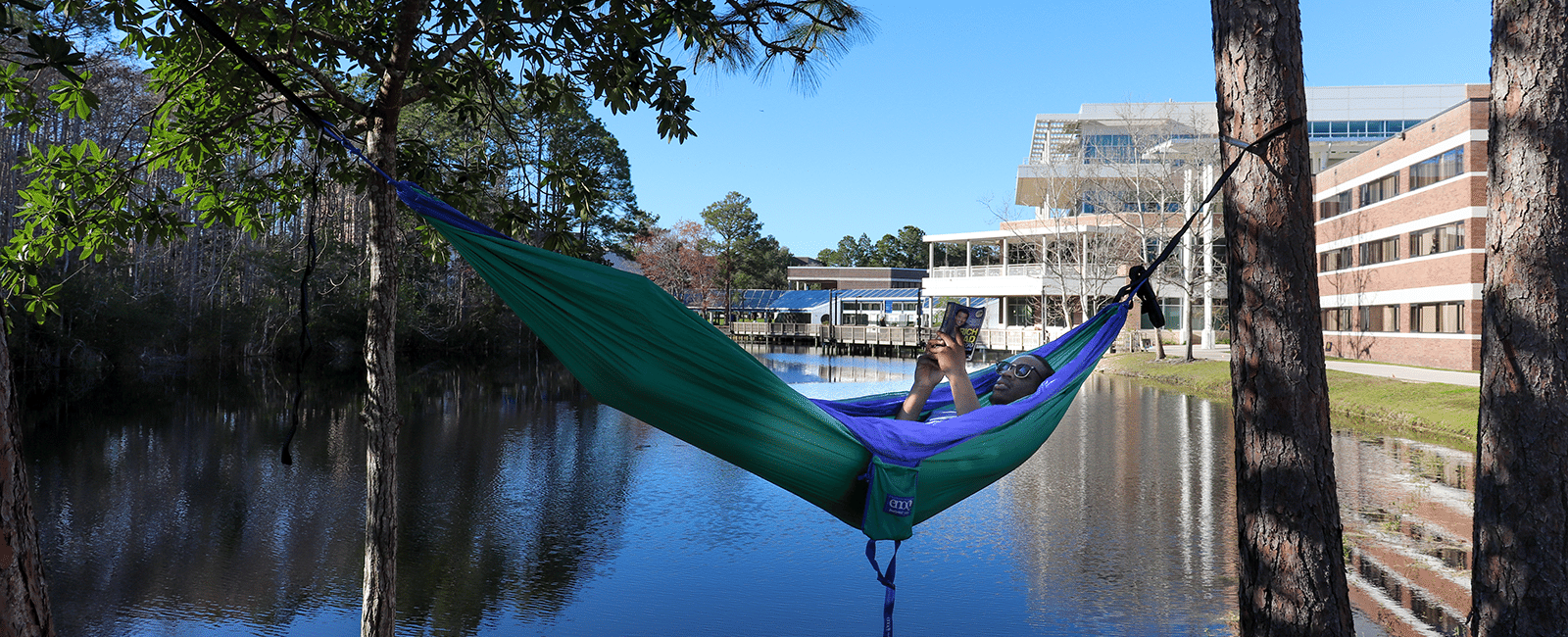 male resident in hammock in housing area with lake in background