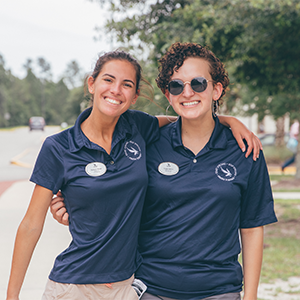 two unf staff members smiling outside