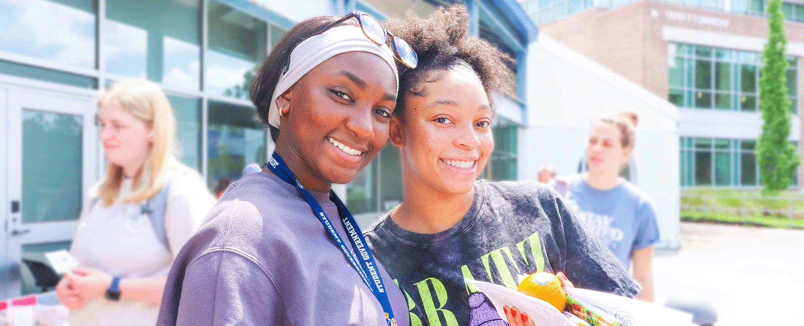 two roommates smiling on a bright beautiful day at de-stress fest