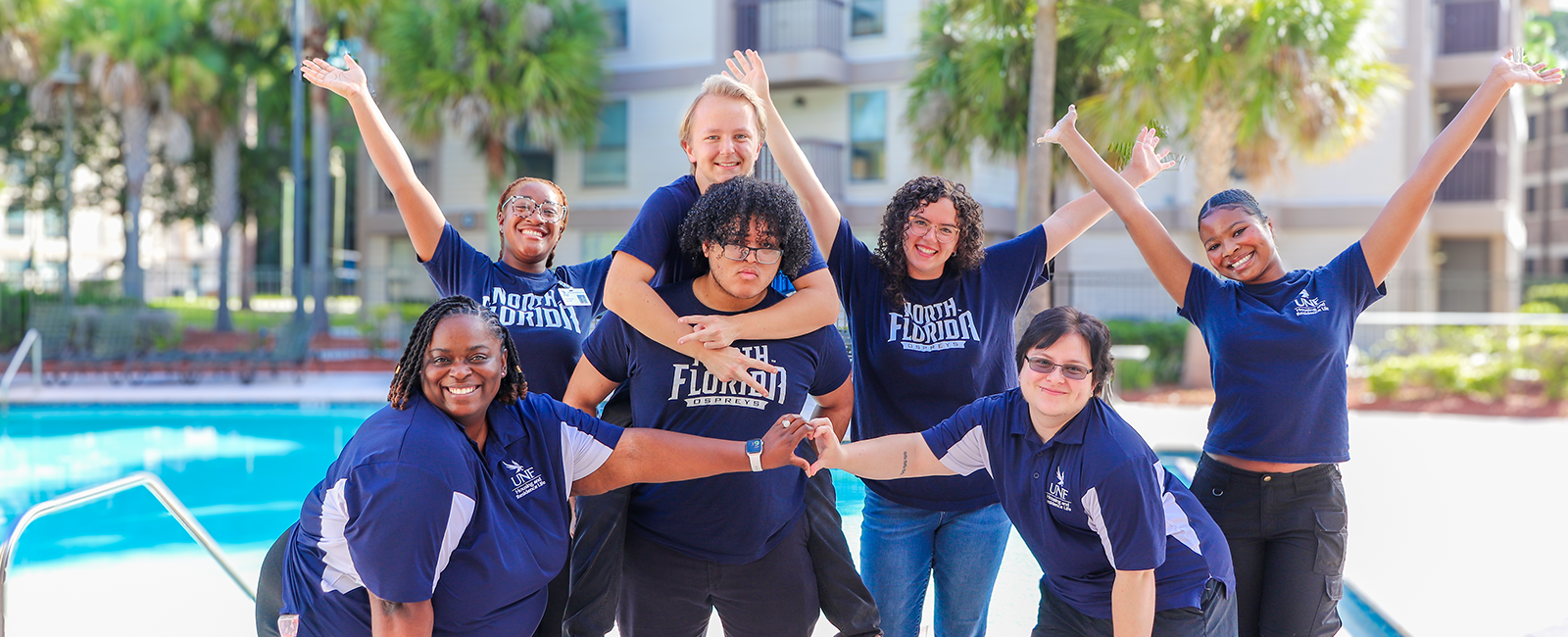 Osprey Hall Student Staff posing for a fun photo in front of Osprey Clubhouse pool
