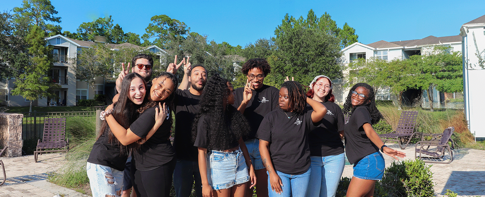 Student staff members of the Flats at UNF smiling, posing for a photo