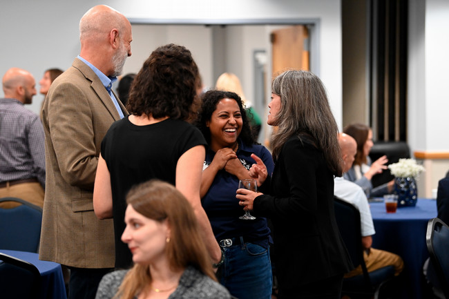 UNF employees mingling at a social event with drinks