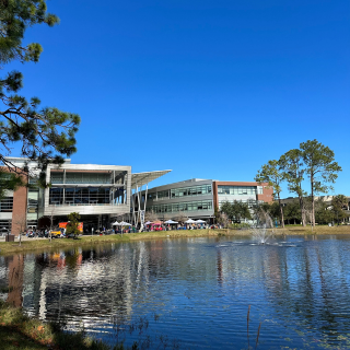 A photo of the UNF Student Union on a sunny day with a pond in the forefront