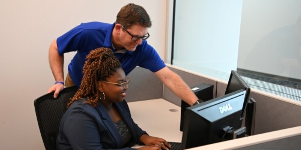 Employee helping student with cybersecurity