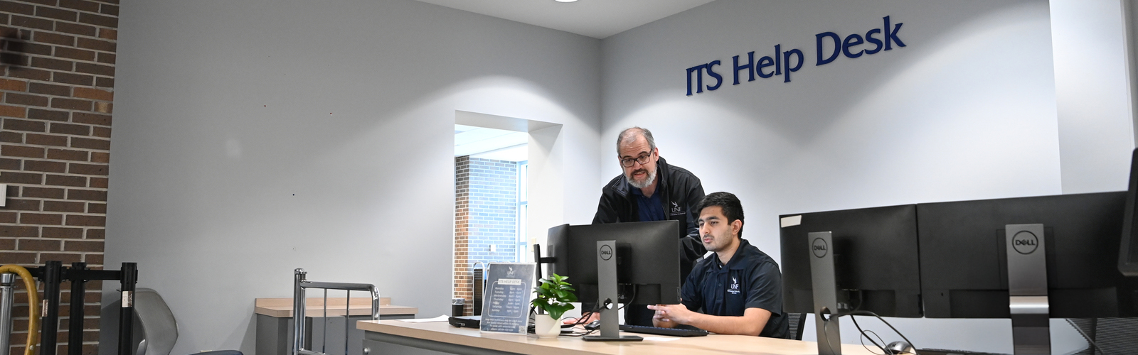 Employee helping a student employee at the Help Desk