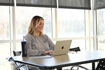 An employee smiling using a laptop