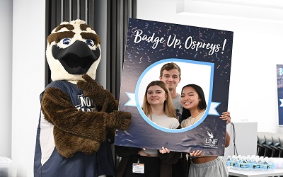 Ozzie the osprey with three smiling students