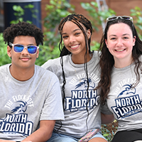 three students in unf shirts