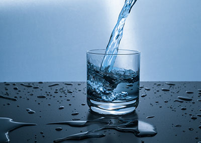 Person pouring water into a glass