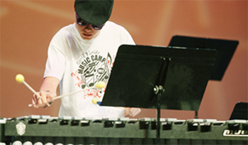 A music camp student playing a xylophone
