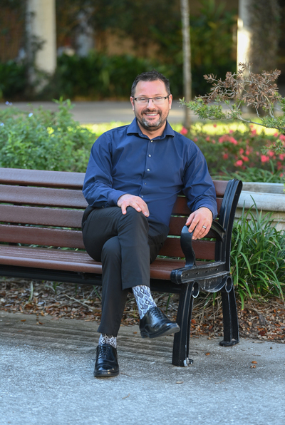 Dr. Misha Bogomaz sitting on a bench