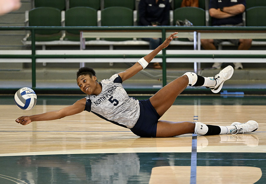 Mahalia White on volleyball court diving for a ball