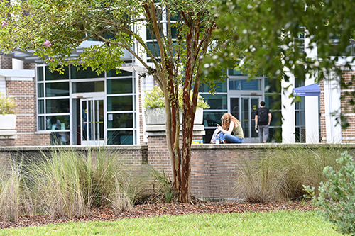 Student sitting outside the library